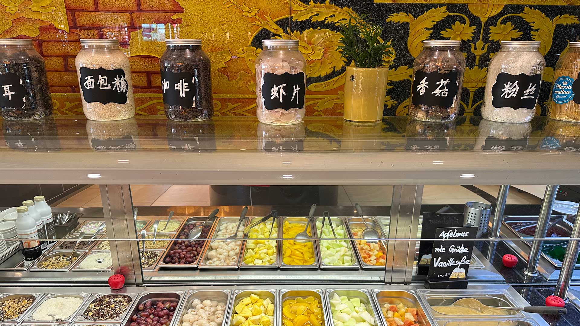 Eine Selbstbedienungstheke mit verschiedenen Obst- und Nussfleischsorten in Behältern.
