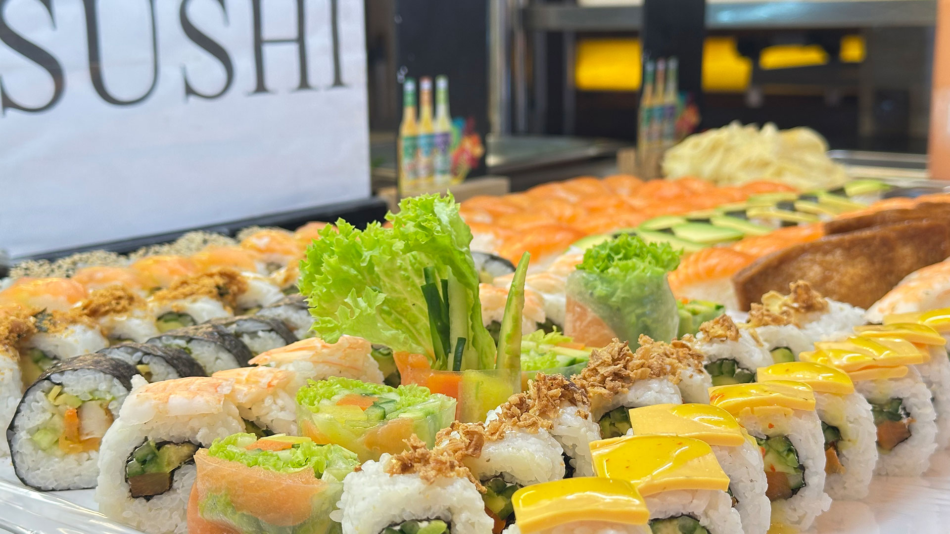 Verschiedene Sushi-Rollen auf einem Tisch, farbenfroh und frisch mit dekorativem Gemüse.